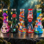 Four handcrafted, highly decorated glass water pipes standing on a dark stone surface in a forest setting with sunbeams filtering through the background.