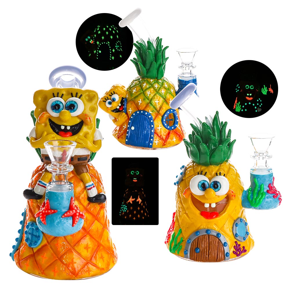 A set of Sponge-themed glass smoking accessories on a white background, including pineapple-shaped holders, a glass bong, a glass pipe, and two circular insets showing glow-in-the-dark designs.